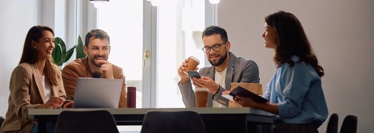 Vier Business-Professionals in informeller Besprechung – symbolisiert vertrauensvolle Zusammenarbeit und Führungsentscheidungen im Private-Equity-Umfeld.
